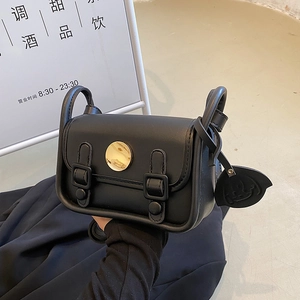 Minimalist black leather mini crossbody bag with golden buckle and leaf charm