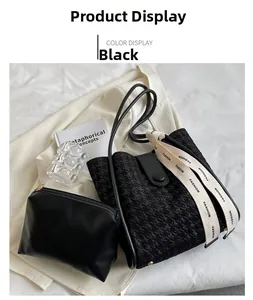 Close-up of black tote bag set with jacquard texture and woven 'FASHION' strap details