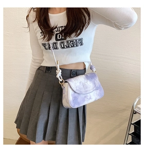 Detail view of purple marble pattern crossbody bag with decorative white knotted strap