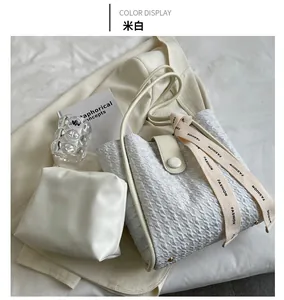 Close-up of cream textured bucket bag with a fashion strap and matching inner pouch