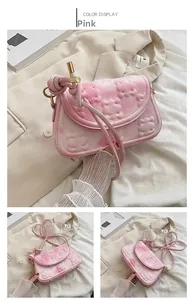 Close-up of pink crossbody bag with 3D bear relief, knotted strap, and gold metal accents