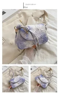 Close-up of blue marble textured shoulder bag with cloud embossed finish and knotted strap