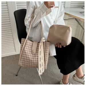 Detail of large houndstooth tote bag set with ribbon deco and matching small leather pouch