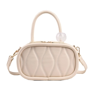 Chic beige crossbody bag with wavy quilted pattern and marble bead charm on top handle