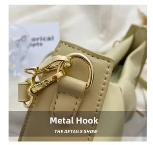 Macro shot of durable gold-tone metal hook and D-ring on beige leather handbag