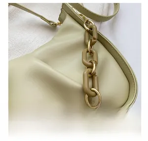 Detail view of the fine stitching and acrylic chain strap on light green cloud bag