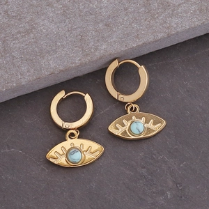 Gouden evil eye oorringen met turquoise kraal en zonnestraal detail op stenen basis