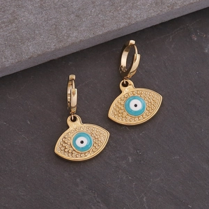 Gouden roestvrijstalen oorringen met blauw emaille oog op een donkere stenen achtergrond