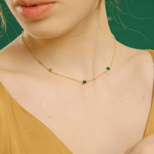 Collier doré élégant orné de trois zircons verts carrés pour un look chic à la française