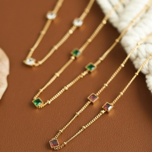 Collier en acier titane doré avec des cristaux carrés en blanc vert et rouge chic