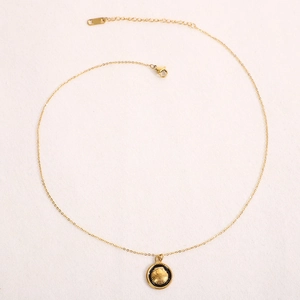 Detail of gold O-chain necklace featuring shell relief pendant with black enamel finish