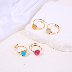Adjustable gold plated rings with teardrop gemstones in four colors on marble and silk