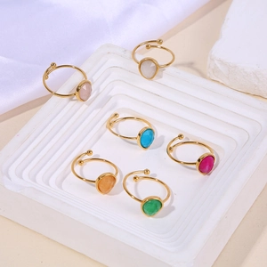 Detail view of colorful teardrop natural stone rings on white tiered display stands