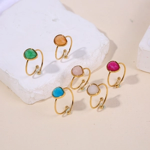 Detailed shot of six gold-plated open rings with colorful teardrop natural stones