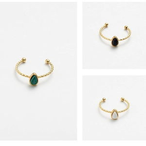 Three teardrop natural stone rings in malachite, onyx, and mother of pearl on gold bands