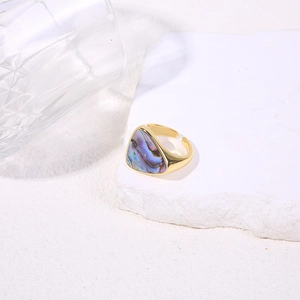 Macro view of gold triangle ring featuring iridescent shell inlay on white stone base