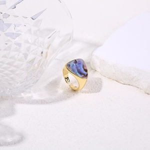 Detailed view of an adjustable gold ring featuring an iridescent triangle shell inlay