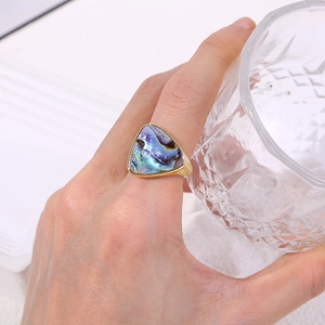 Detail of geometric triangle ring with iridescent abalone inlay and gold finish