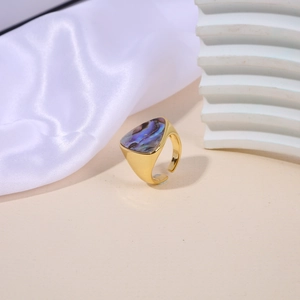 Detail of adjustable gold ring featuring a geometric triangle with abalone shell inlay