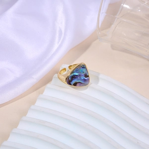 Macro detail of triangle ring featuring iridescent abalone shell inlay and gold finish