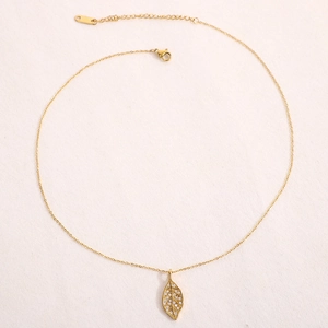 Close-up of golden leaf pendant with sparkling zircons and adjustable chain necklace