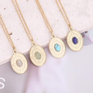 Detail of vintage gold plated necklaces featuring oval colorful natural stone pendants