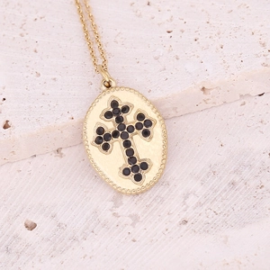 Elegant gold oval cross necklace with black stones on a natural stone background