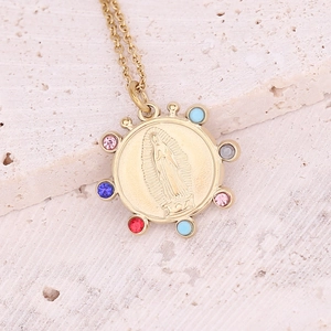 Detailed view of Virgin of Guadalupe gold medallion with colorful gemstones