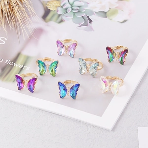 Detailed view of butterfly rings set with faceted gradient crystals and golden bands