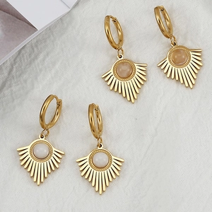 Detail of gold-plated stainless steel hoop earrings with shell-style natural stone pendants