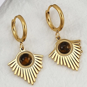 Macro detail of golden hoop earrings featuring sunburst charms with tiger eye stone
