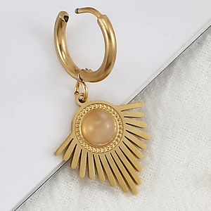 Detail of golden stainless steel earring with sunburst pendant and natural stone inlay