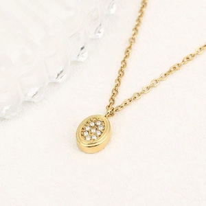Collana dorata con pendente ovale e pietre incastonate lucenti per un look estivo chic