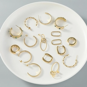 Ensemble de boucles d'oreilles créoles dorées martelées sur un plateau en céramique