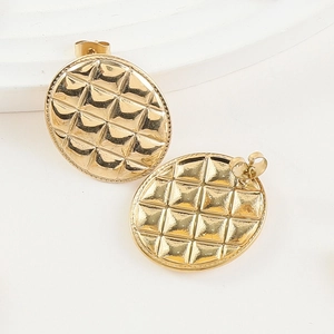 Détail de boucles d'oreilles ovales dorées avec texture matelassée et fini poli