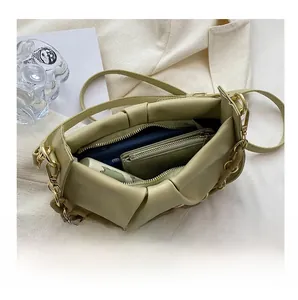 Interior detail of sage green pleated cloud bag with chain and matching coin purse