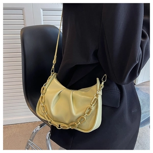 Detail of lime yellow pleated cloud bag with chunky acrylic chain and leather strap