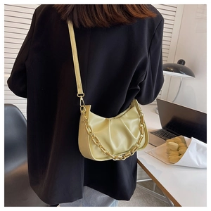 Detail of light green pleated croissant bag with resin chain and slim leather shoulder strap