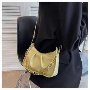 Detail of light green pleated hobo bag with thick chain handle and smooth leather texture