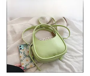 Mini sac croissant vert clair avec pochette beige et téléphone pour référence de taille