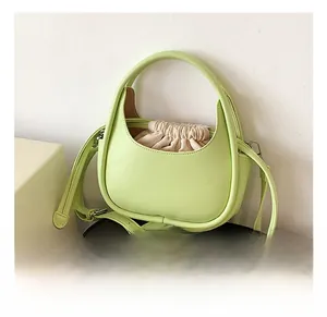 Détail du sac vert menthe avec poignée ronde, bandoulière et doublure à cordon coulissant
