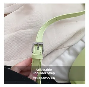 Gros plan sur la bandoulière réglable en cuir vert clair avec boucle en métal argenté