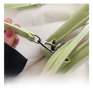 Détail du crochet en métal argenté brillant sur le sac à bandoulière vert avocat