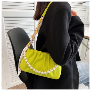 Detail of neon green pleated cloud bag with pearl chain and printed silk scarf strap