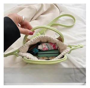 Détail du mini sac vert clair montrant l'intérieur spacieux avec doublure à cordon