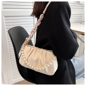 Detail of off-white ruched cloud bag featuring pearl chain and scarf-wrapped strap