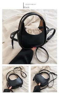 Détail du sac bandoulière demi-lune noir avec doublure à cordon blanche et texture en cuir