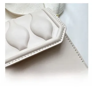 Detailed close-up of cream textured faux leather bag with embossed wave pattern and BAGS logo