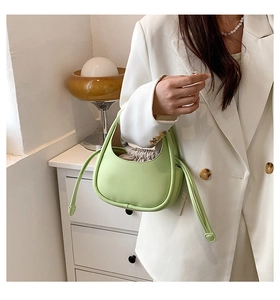 Détail d'un mini sac à main vert clair avec silhouette arrondie et doublure à cordon