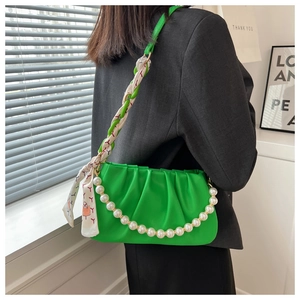 Fashionable green pleated cloud bag with pearl chain and silk scarf worn by a model